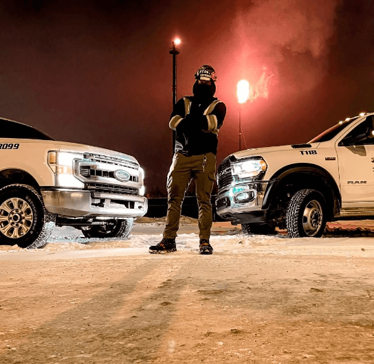 Team-member standing between service trucks